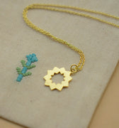 Håndlavet sol-halskæde i 24 karat forgyldt sølv fra Afghanistan. Elegant og kort choker-design med et solinspireret vedhæng. Leveres i en broderet stofpose.