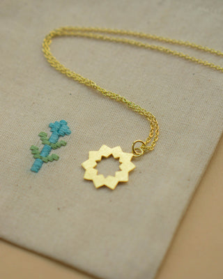 Håndlavet sol-halskæde i 24 karat forgyldt sølv fra Afghanistan. Elegant og kort choker-design med et solinspireret vedhæng. Leveres i en broderet stofpose.