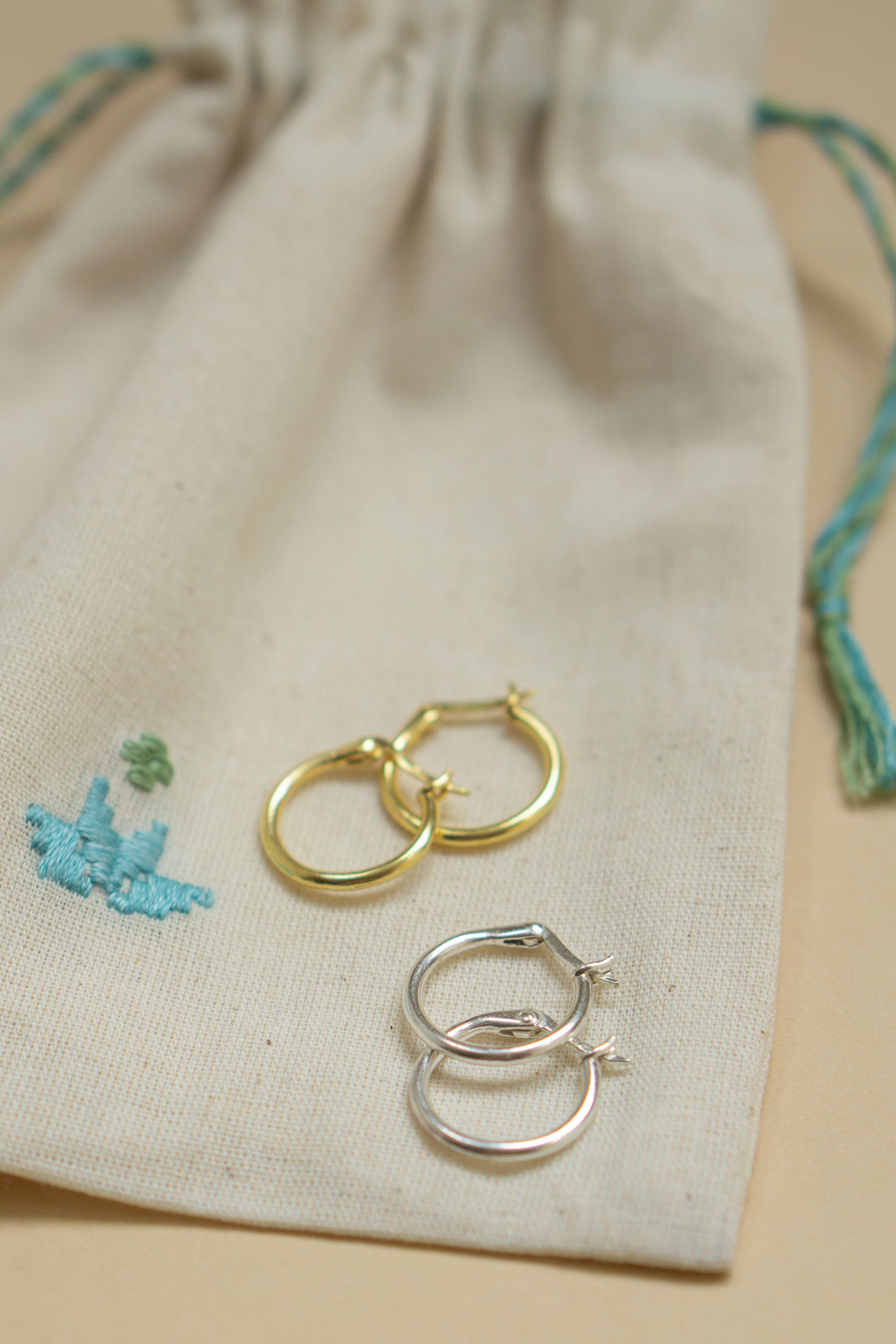 Håndlavede simple hoops i 925-sterling sølv og 24 karat forgyldt sølv fra Afghanistan. Smukt præsenteret på en håndbroderet smykkepose, skabt af kvindelige håndværkere. En elegant og meningsfuld gave.