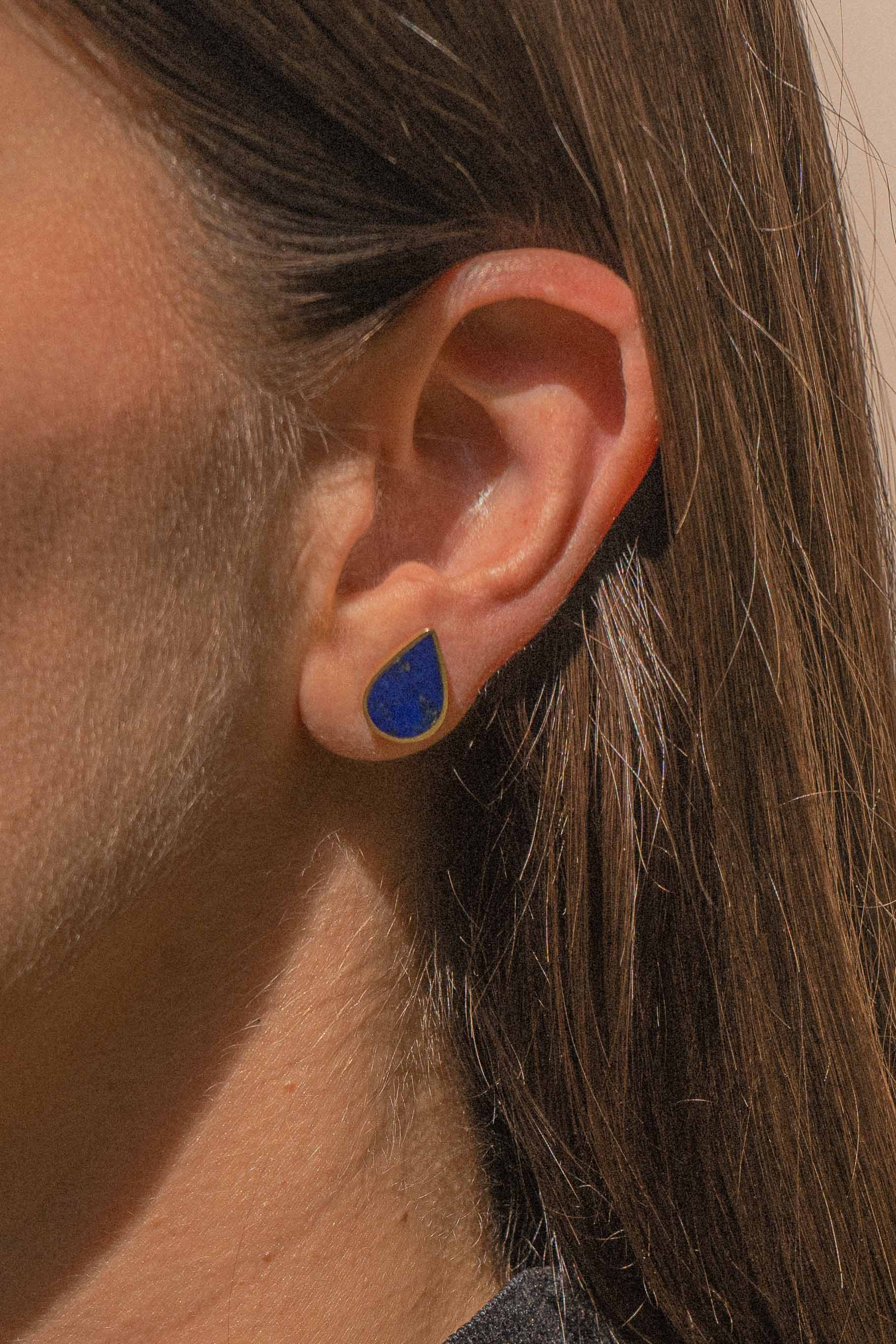 Elegant ørestikker i 24 karat forgyldt sølv med dybblå lapis lazuli sten, båret af model. En del af Chashma-serien, inspireret af Afghanistans naturlige vandkilder.