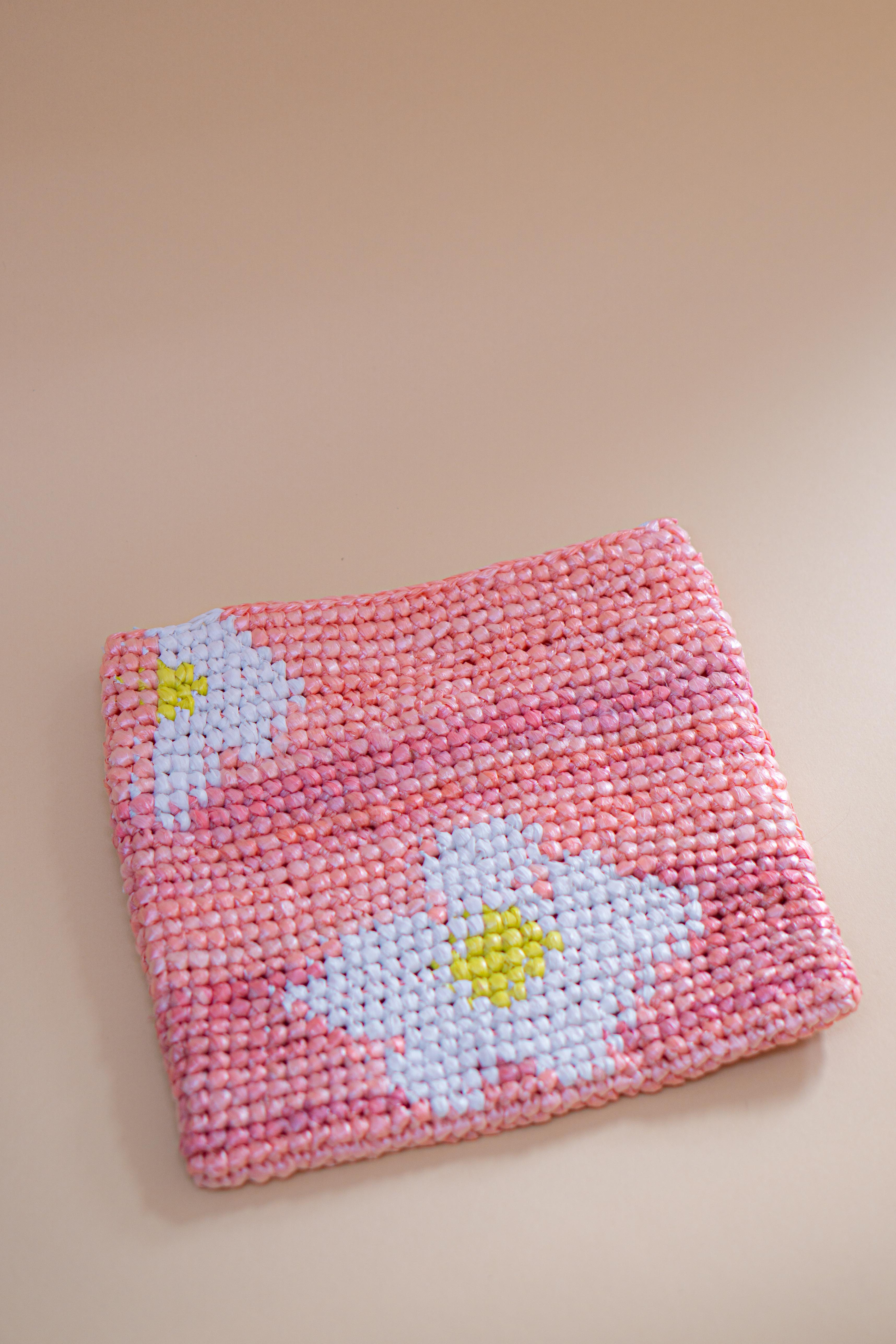 Bæredygtig blomsterclutch håndlavet af genanvendt plastik. Unikt design dekoreret med blomster, skabt med omtanke for miljøet. Perfekt som gave eller til hverdag.