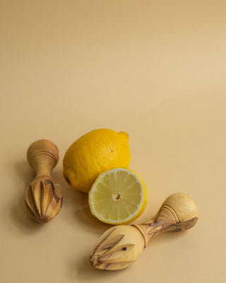Håndlavet citruspresser i oliventræ med citron som baggrund. Perfekt til at presse saft fra citrusfrugter.